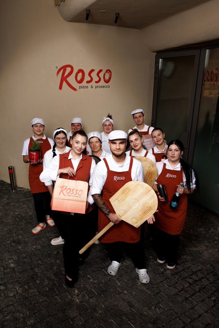 Команда закладу з лопатами й коробками біля вивіски Rosso